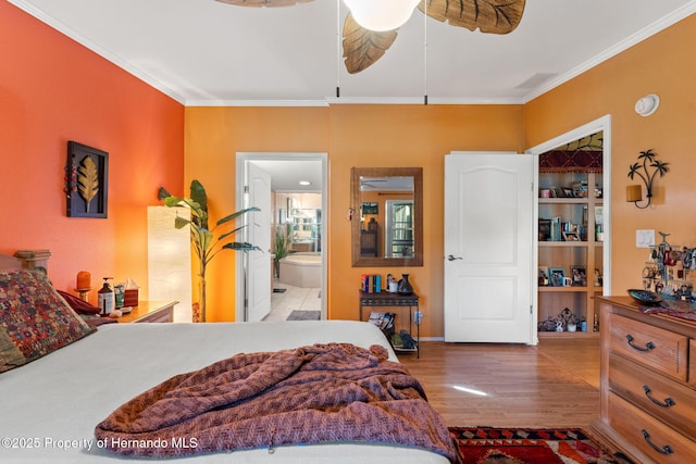 bedroom with crown molding, hardwood / wood-style flooring, ceiling fan, and ensuite bathroom