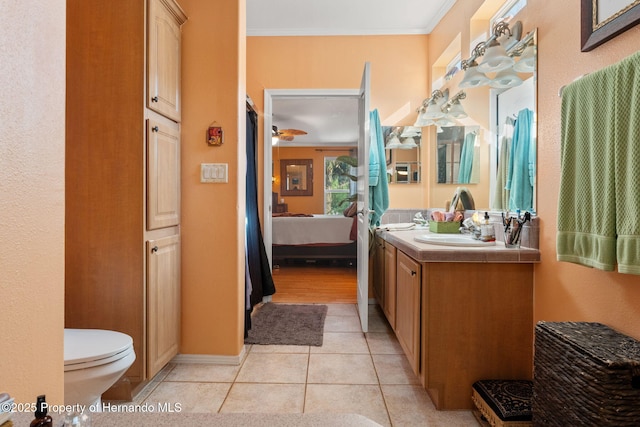 bathroom featuring tile patterned flooring, vanity, crown molding, and toilet