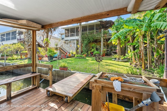 wooden terrace with a yard and a sunroom