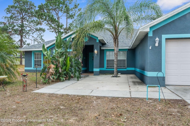 view of exterior entry featuring stucco siding and a garage