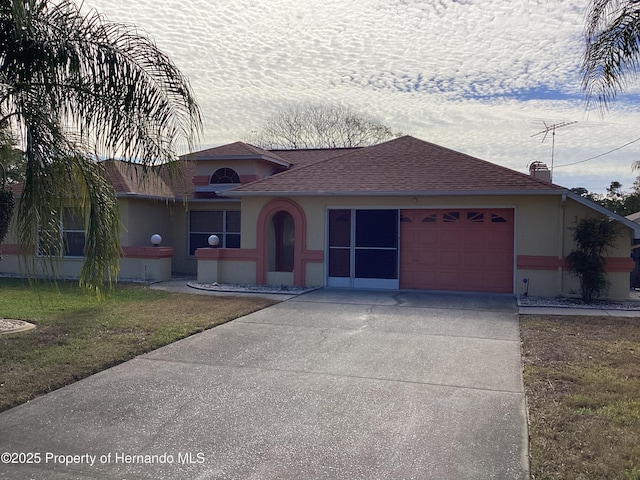 ranch-style home with a garage and a front lawn