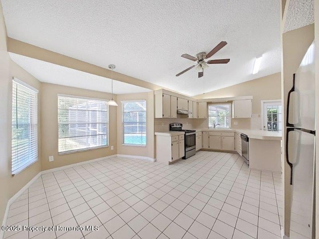 kitchen featuring ceiling fan, backsplash, vaulted ceiling, light tile patterned floors, and appliances with stainless steel finishes