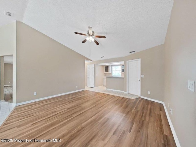 unfurnished living room with a textured ceiling, light hardwood / wood-style flooring, and ceiling fan