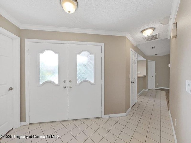 entrance foyer with light tile patterned flooring, ornamental molding, and a textured ceiling