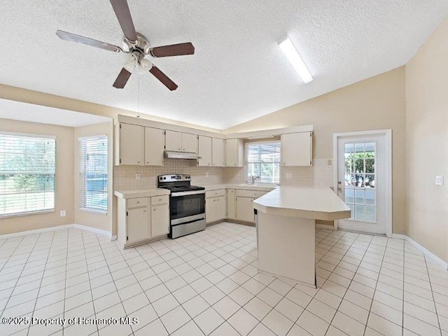 kitchen featuring a kitchen breakfast bar, kitchen peninsula, lofted ceiling, stainless steel range with electric stovetop, and light tile patterned floors