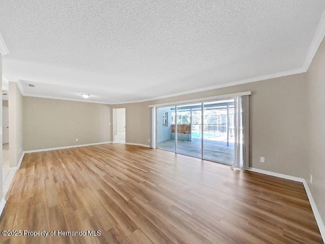 spare room with a textured ceiling, light hardwood / wood-style flooring, and crown molding