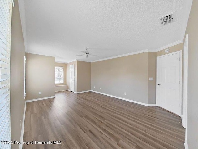 empty room featuring ceiling fan, dark hardwood / wood-style flooring, crown molding, and a textured ceiling