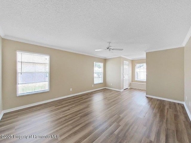 spare room featuring wood-type flooring, a textured ceiling, ceiling fan, and crown molding