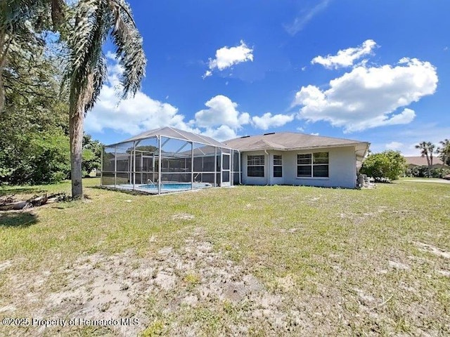 rear view of property featuring a lanai and a lawn