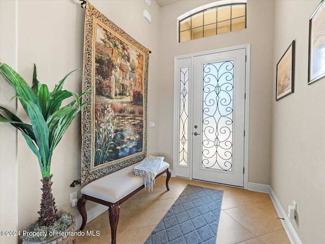 tiled entryway with a towering ceiling