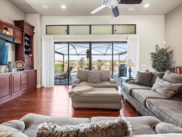 living room with ceiling fan and dark hardwood / wood-style flooring