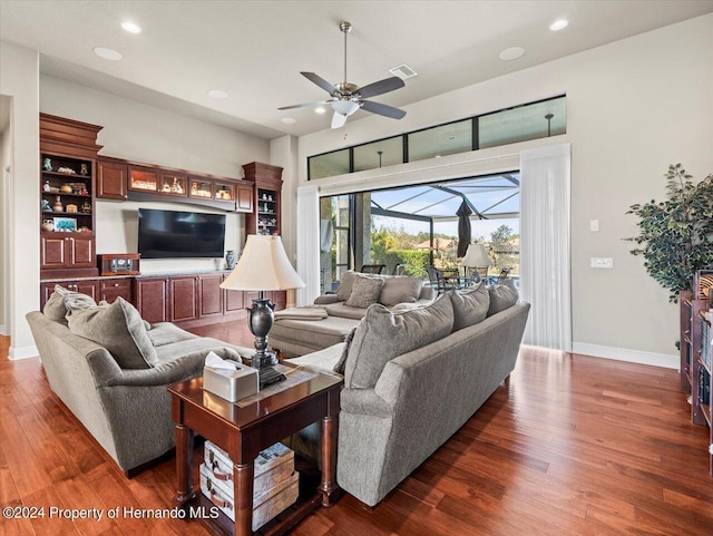 living room featuring dark hardwood / wood-style flooring and ceiling fan