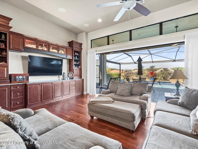 living room featuring ceiling fan, dark hardwood / wood-style flooring, and a wealth of natural light