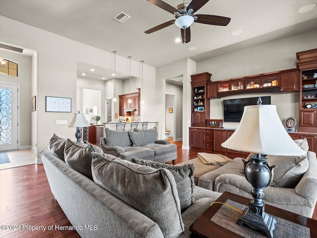 living room featuring ceiling fan and dark hardwood / wood-style flooring