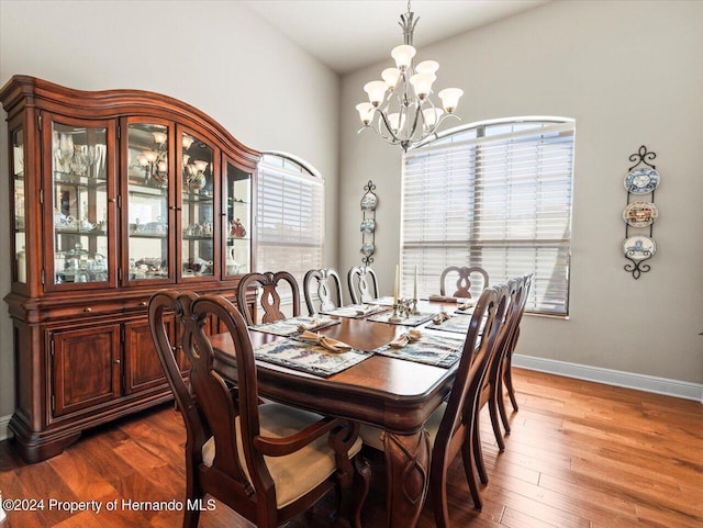 dining room featuring wood-type flooring and an inviting chandelier