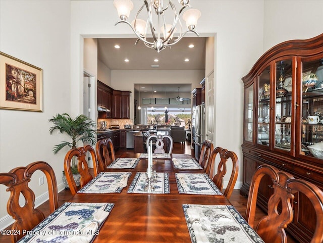 dining space with dark hardwood / wood-style floors and a notable chandelier