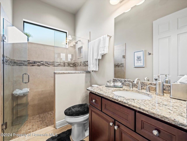 bathroom with tile patterned flooring, vanity, toilet, and a shower with shower door