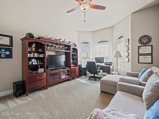 living room featuring ceiling fan, light colored carpet, and a textured ceiling