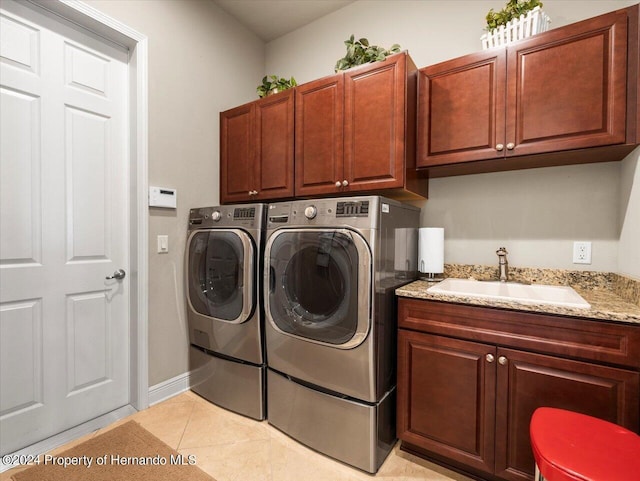 washroom with washer and clothes dryer, sink, light tile patterned flooring, and cabinets