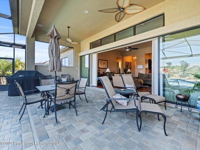 view of patio featuring glass enclosure and ceiling fan