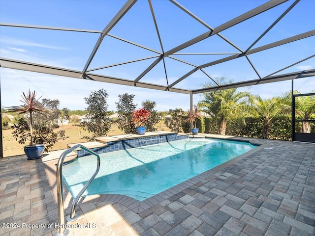 view of pool with a patio area and a lanai