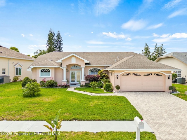 ranch-style house featuring central air condition unit, a front lawn, and a garage