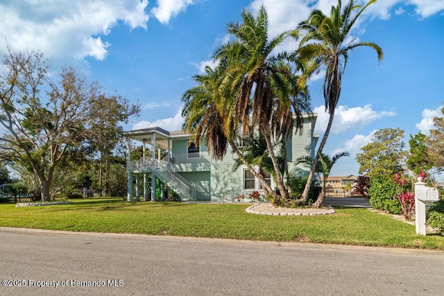 raised beach house with a porch and a front lawn