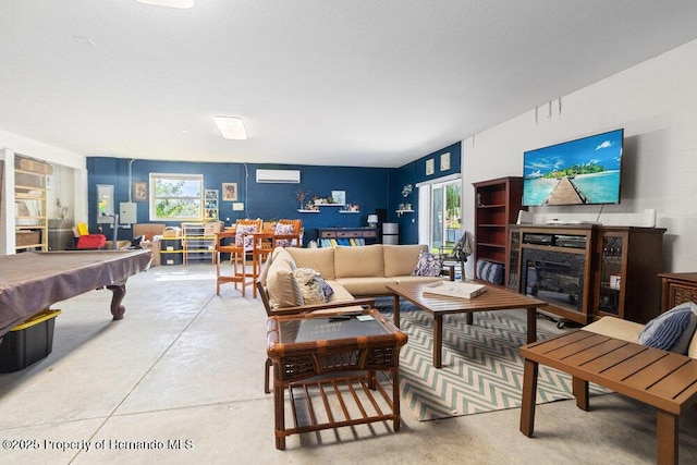 living room with a fireplace, concrete floors, a wall unit AC, and billiards