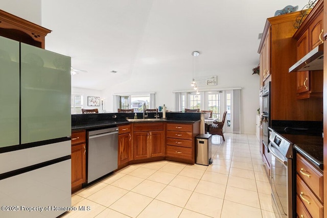 kitchen with kitchen peninsula, stainless steel appliances, sink, hanging light fixtures, and light tile patterned flooring