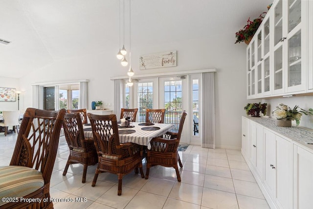 dining room featuring light tile patterned floors and vaulted ceiling