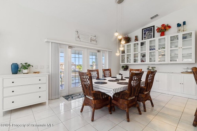 tiled dining space featuring lofted ceiling