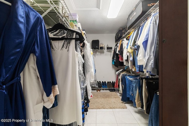 walk in closet with light tile patterned floors