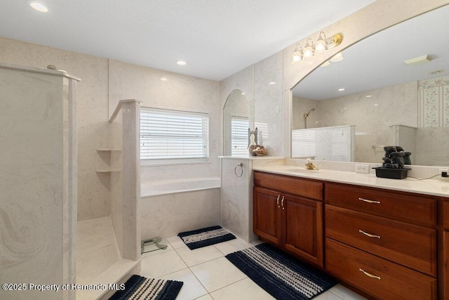 bathroom featuring vanity, tile patterned floors, tile walls, and separate shower and tub