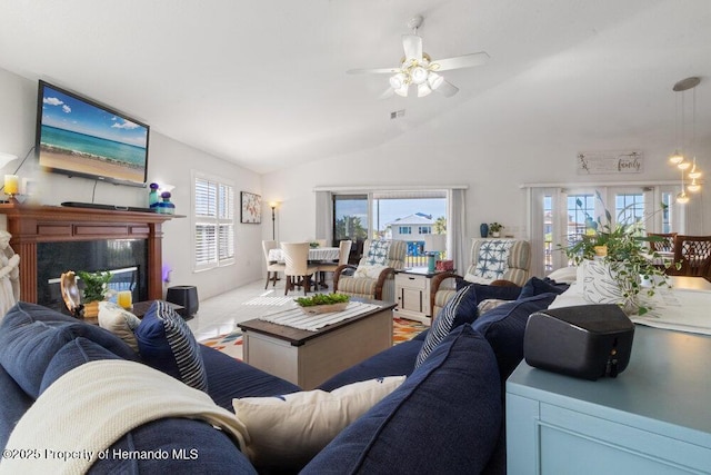 living room with a fireplace, vaulted ceiling, and ceiling fan