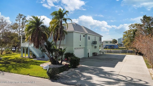 view of side of property featuring a garage, a yard, and central AC