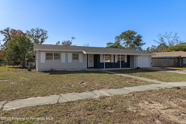 ranch-style house featuring central AC, a garage, and a front lawn