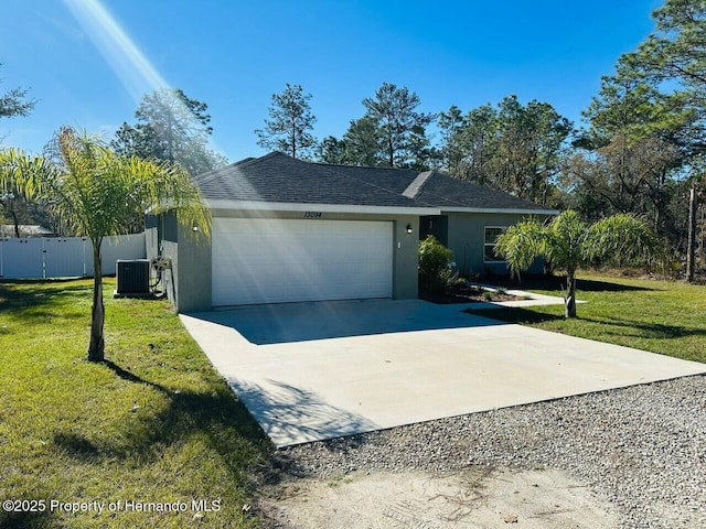 ranch-style house with cooling unit, a front yard, and a garage