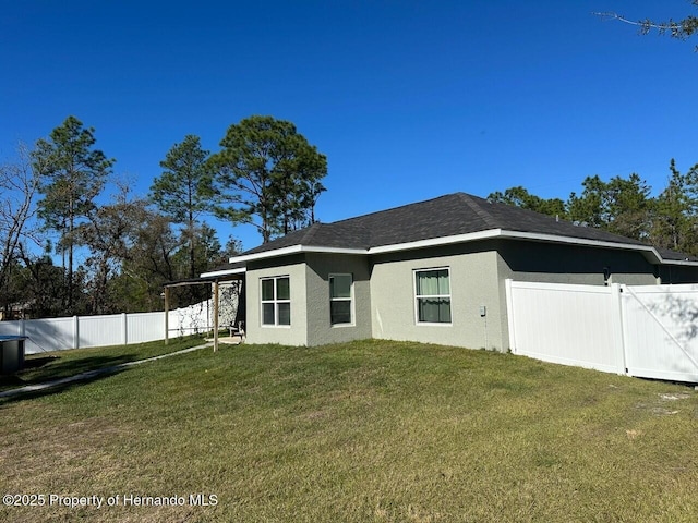 rear view of property featuring a lawn