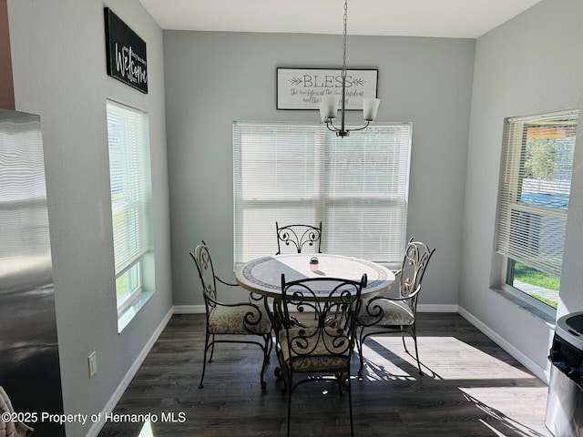 dining area with a wealth of natural light, dark wood-type flooring, and a notable chandelier