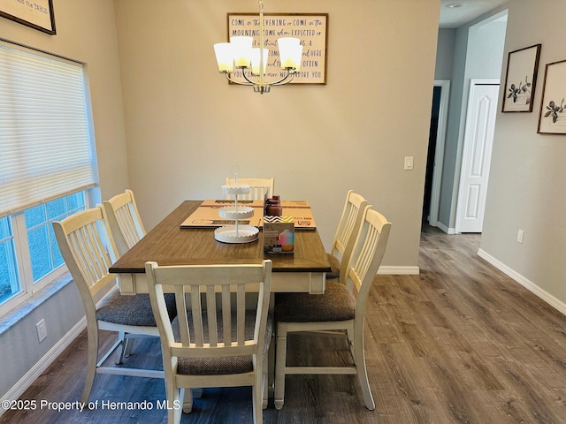 dining area with hardwood / wood-style floors and a notable chandelier