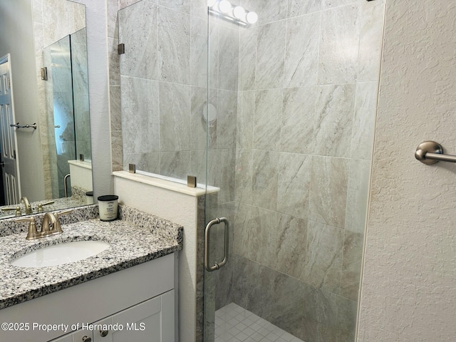 bathroom with vanity and a shower with shower door