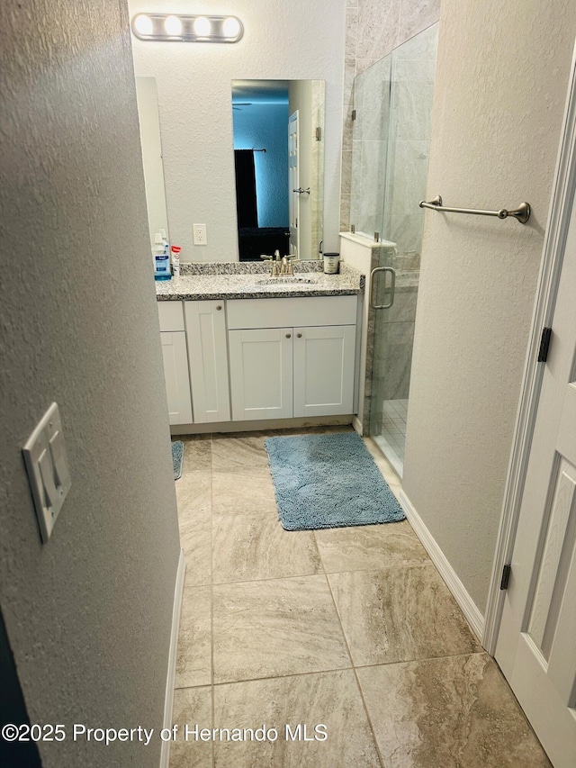 bathroom with vanity and a shower with shower door