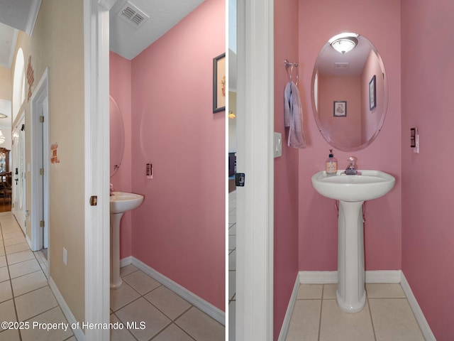 bathroom with a textured ceiling and tile patterned floors