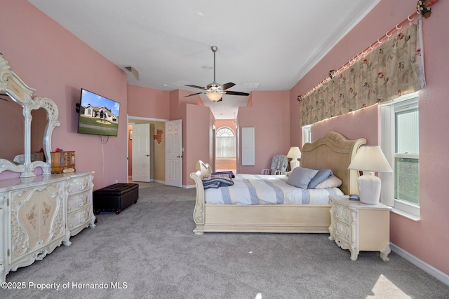 carpeted bedroom with multiple windows and ceiling fan