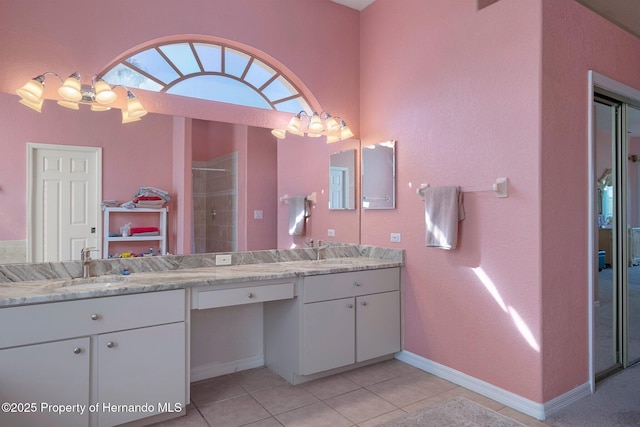 bathroom featuring a tile shower, vanity, and tile patterned floors