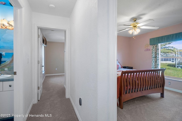 bedroom with sink, ceiling fan, and carpet flooring