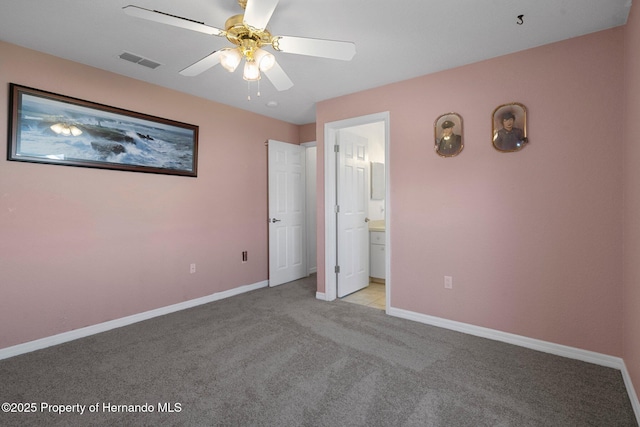 unfurnished bedroom featuring ceiling fan, light carpet, and ensuite bath