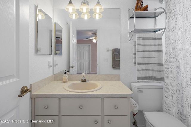 bathroom with toilet, vanity, and ceiling fan