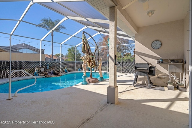 view of swimming pool featuring glass enclosure and a patio area