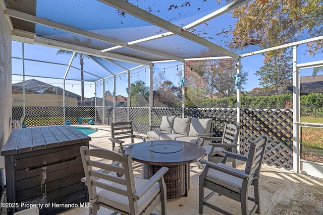 view of patio featuring a fenced in pool, glass enclosure, and outdoor lounge area